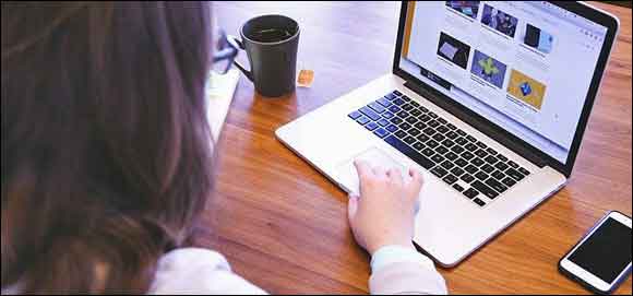 Young person online wit laptop and phome.